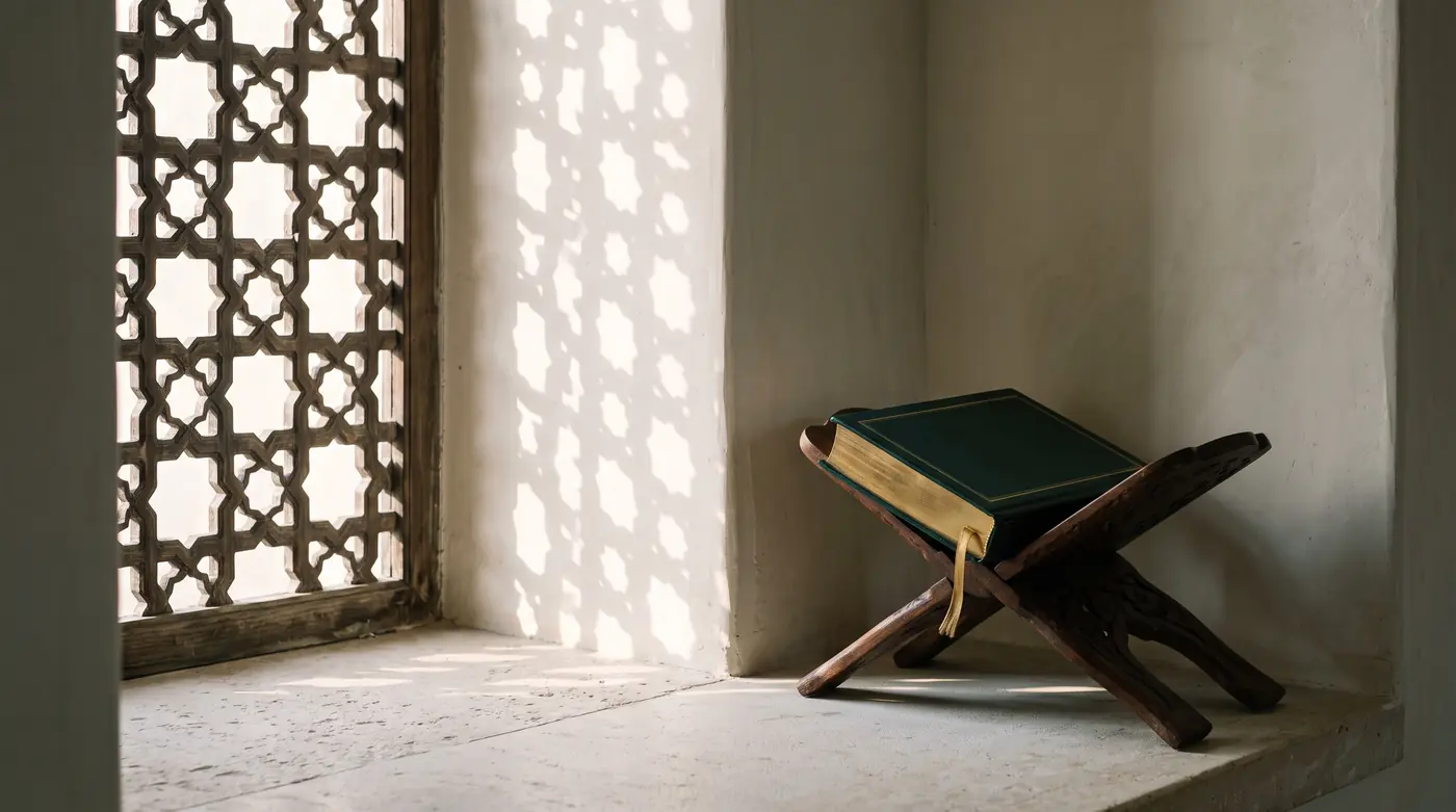 Un livre relié de cuir vert émeraude, fermé, sur un support de lecture en bois sculpté, dans la lumière en étoiles d’un moucharabieh